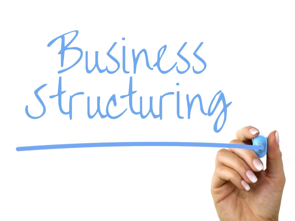 image of the words 'businessl structuring' underlined in blue by a sharpie in a female hand